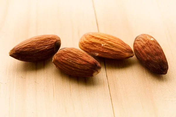 Almonds isolated on wooden background — Stock Photo, Image