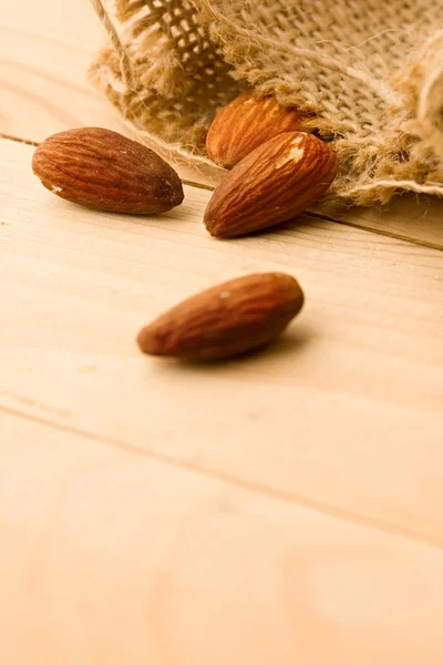 Almonds isolated on wooden background — Stock Photo, Image