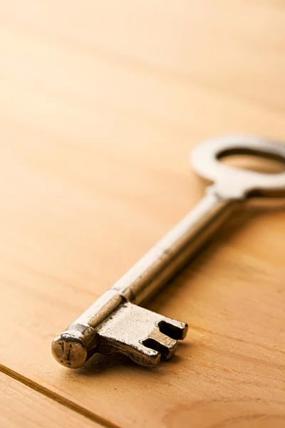Ключ изолирован на деревянном фоне — стоковое фото