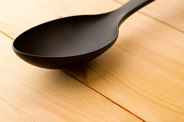 Spoon isolated on wooden background — Stock Photo, Image