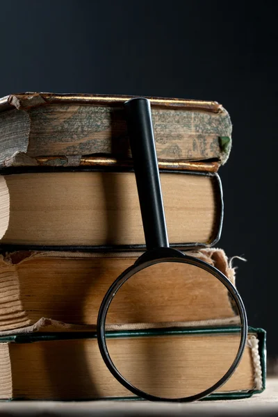Old books with magnifying glass — Stock Photo, Image