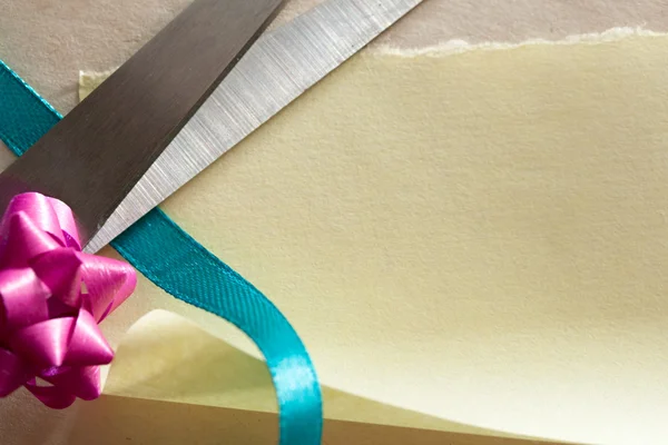 Ножницы, лук и лента на бумаге — стоковое фото