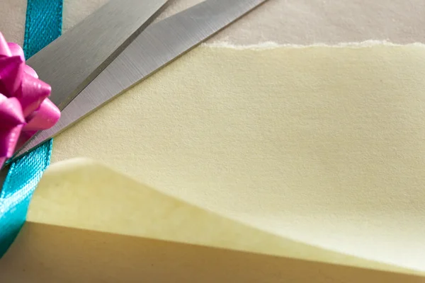 Ножницы, лук и лента на бумаге — стоковое фото