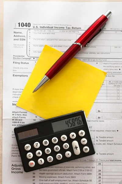 Formulario de impuestos, bolígrafo rojo, calculadora y pegatina — Foto de Stock