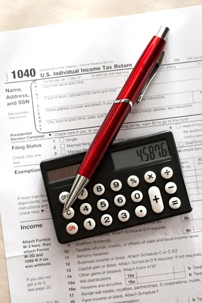 Налоговая форма, красная ручка и калькулятор — стоковое фото