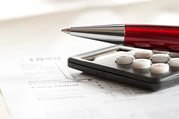 Formulário fiscal, caneta vermelha e calculadora — Fotografia de Stock