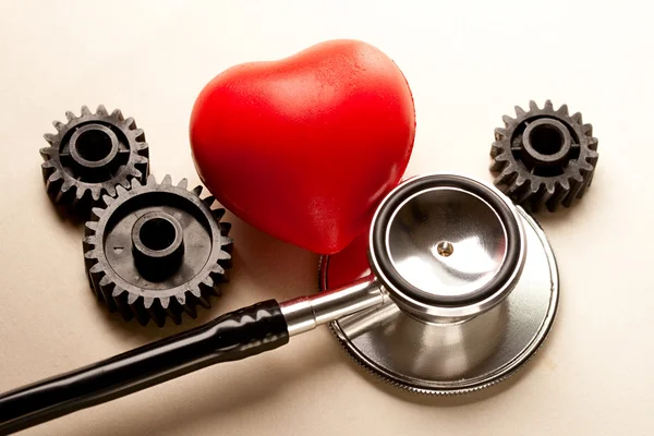Raquetes mecânicos, estetoscópio e coração vermelho — Fotografia de Stock