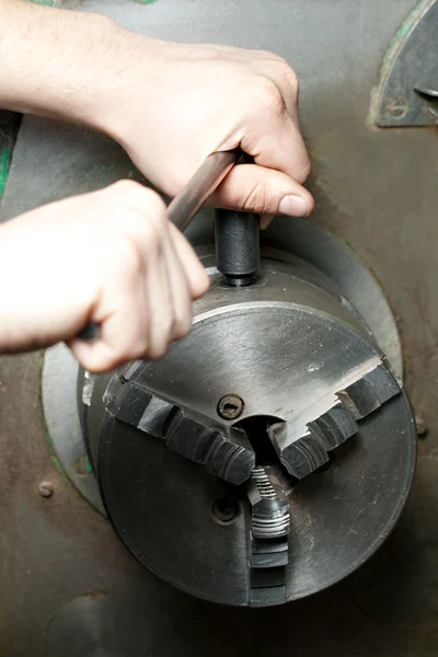 Regulating of turning lathe with hands — Stock Photo, Image