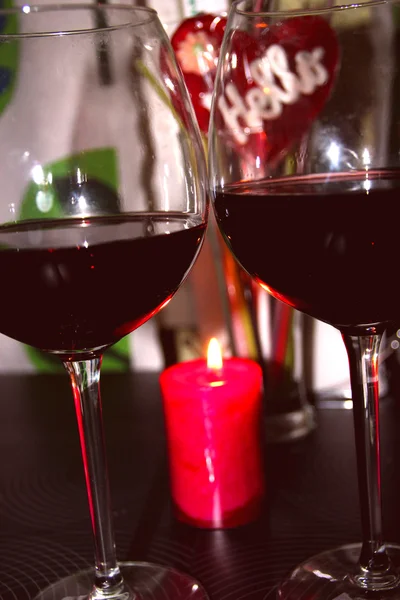 Dos copas de vino tinto junto a las velas — Foto de Stock