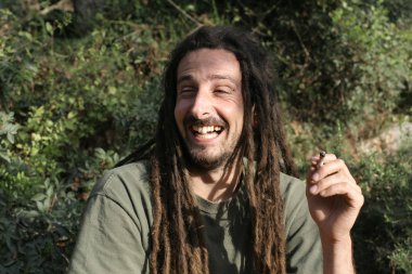 Hippy preparing, rolling and smoking marijuana joint : photos series clipart