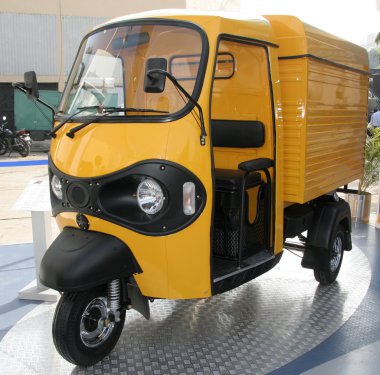 Yellow three wheeler pickup at autoexpo in delhi, india clipart