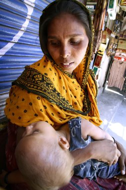 Woman beggar with her baby, delhi, india clipart