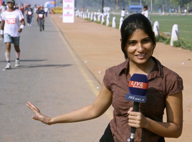 Young female journalist covering the marathon, delhi, india clipart
