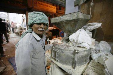 Man at flour mill, delhi, india clipart