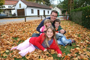 Baba ve üç çocukları sonbahar bir parkta