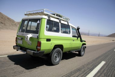 4 wheel drive overtaking on a desert road in sinai, egypt clipart