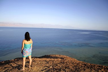 Young woman standing on hill, red sea, sinai, egypt clipart