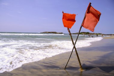 Red warning flags at beach, south india clipart