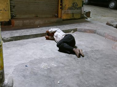 Youth sleeping on footpath, delhi, india clipart