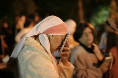 Female Lag Baomer pilgrim praying during festivities. clipart