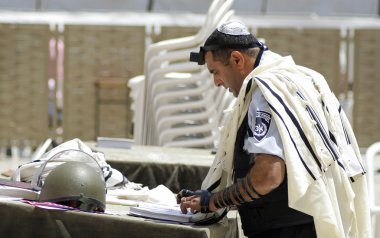 Jewish policeman praying at the wailing wall, jerusalem, israel clipart