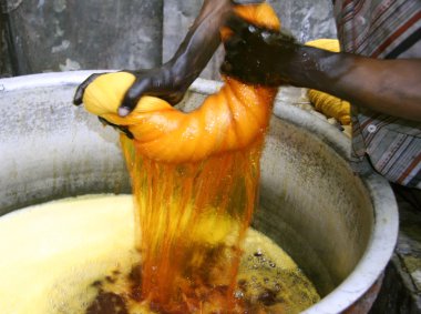 Man wringing cloth during dyeing, delhi, india clipart