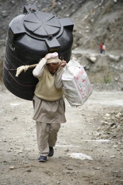 Man carrying water reservoir, annapurna, nepal clipart