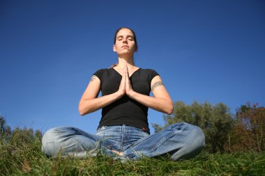 Woman meditating in park clipart