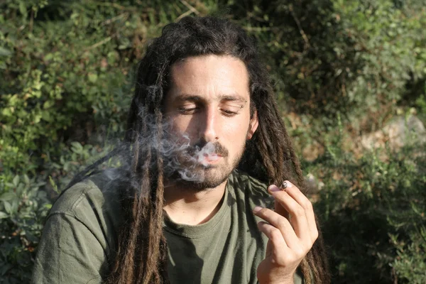 stock image Hippy preparing, rolling and smoking marijuana joint : photos series