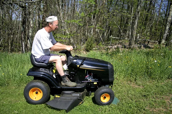 Man sitting on a lawnmower — Stock Photo, Image