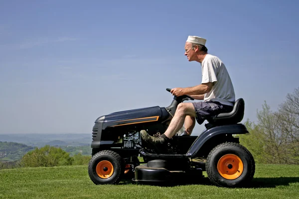 Homem sentado no cortador de grama — Fotografia de Stock