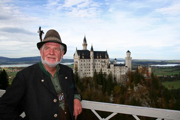 Bavarian hombre en lederhosen posando frente a neuschwanstein castillo —  Fotos de Stock