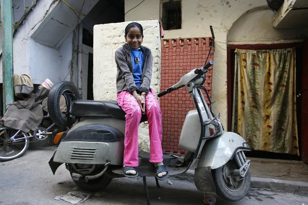 Meisje, zittend op een scooter in straat, delhi, india — Stockfoto