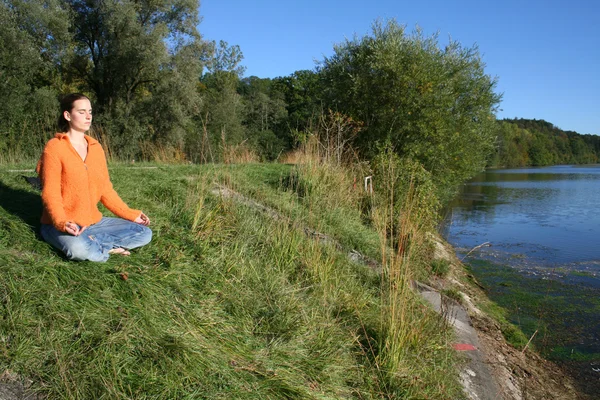 Lady meditating at lake — Stock Photo, Image
