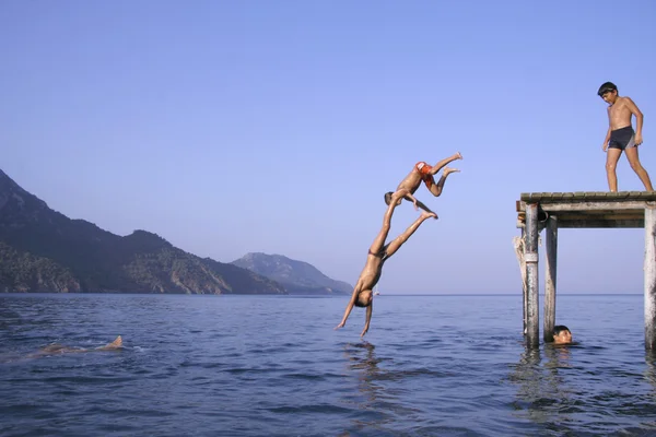 Pojke dykning utanför piren i södra Turkiet — Stockfoto