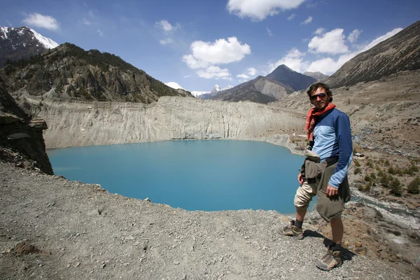 Uomo in piedi sul bordo della scogliera con vista lago di montagna blu, annapurna — Foto Stock