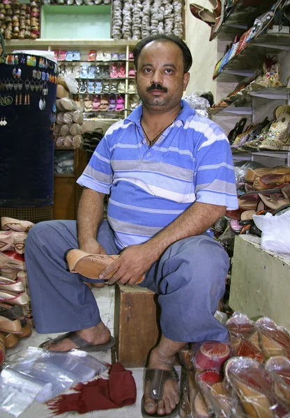 Verkoper binnen een schoeisel winkel, delhi, india — Stockfoto