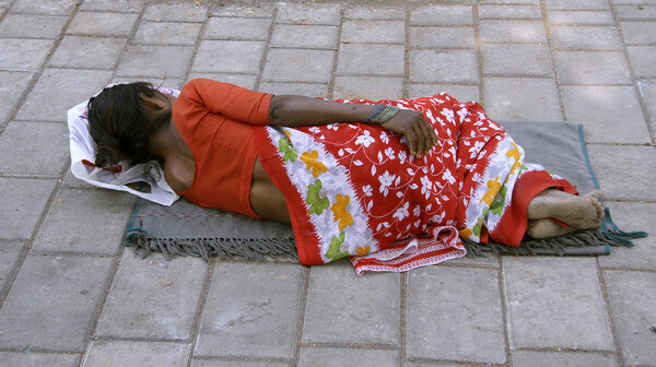 женщина спит на тротуаре, Дели, Индия

