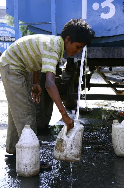 Menino enchendo água em latas, delhi, índia — Fotografia de Stock