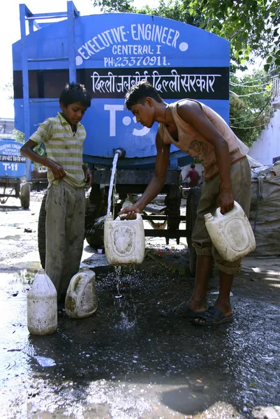 Jungen füllen Wasser in Dosen, Delhi, Indien — Stockfoto