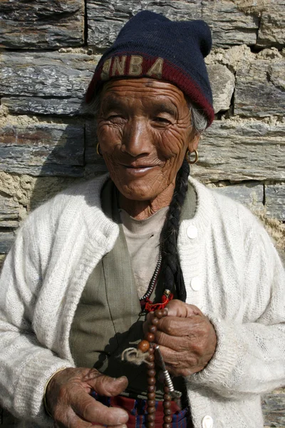 Alte tibetische Dame betet und lächelt mit ihren Mala-Perlen, Annapurna, Nepal — Stockfoto
