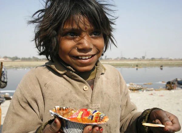 Young indian girl eating with spoon along the yamuna, delhi, india — Stock Photo, Image