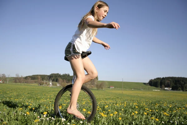 Young girl monocycling in field — Stock Photo, Image