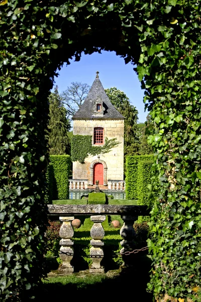 Bush podloubí s výhledem na hrad v zahradách eyrignac, Francie — Stock fotografie