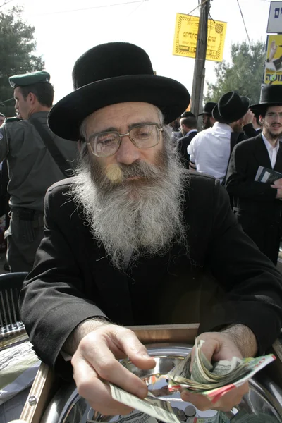 Velho homem judeu barbudo levantando dinheiro — Fotografia de Stock