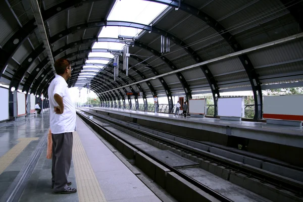 Man in afwachting van trein op nieuwe en moderne metro station. — Stockfoto