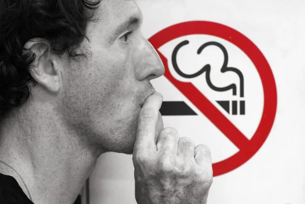 Man smoking a no-smoking sign — Stock Photo, Image
