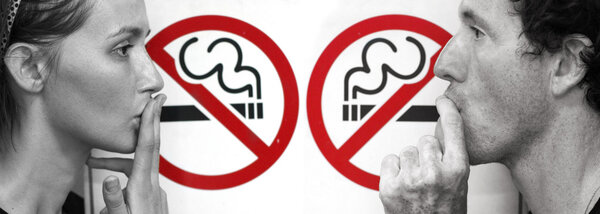 Couple smoking a no smoking sign