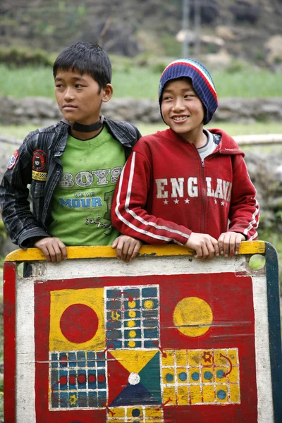 Två unga pojkar poserar med sina chosar brädspel, annapurna, nepal — Stockfoto