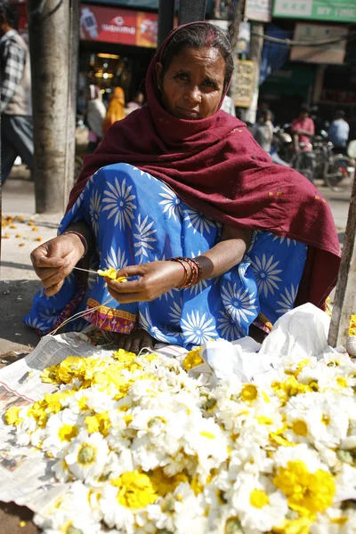 Леди готовит цветы для подношений в храме — стоковое фото